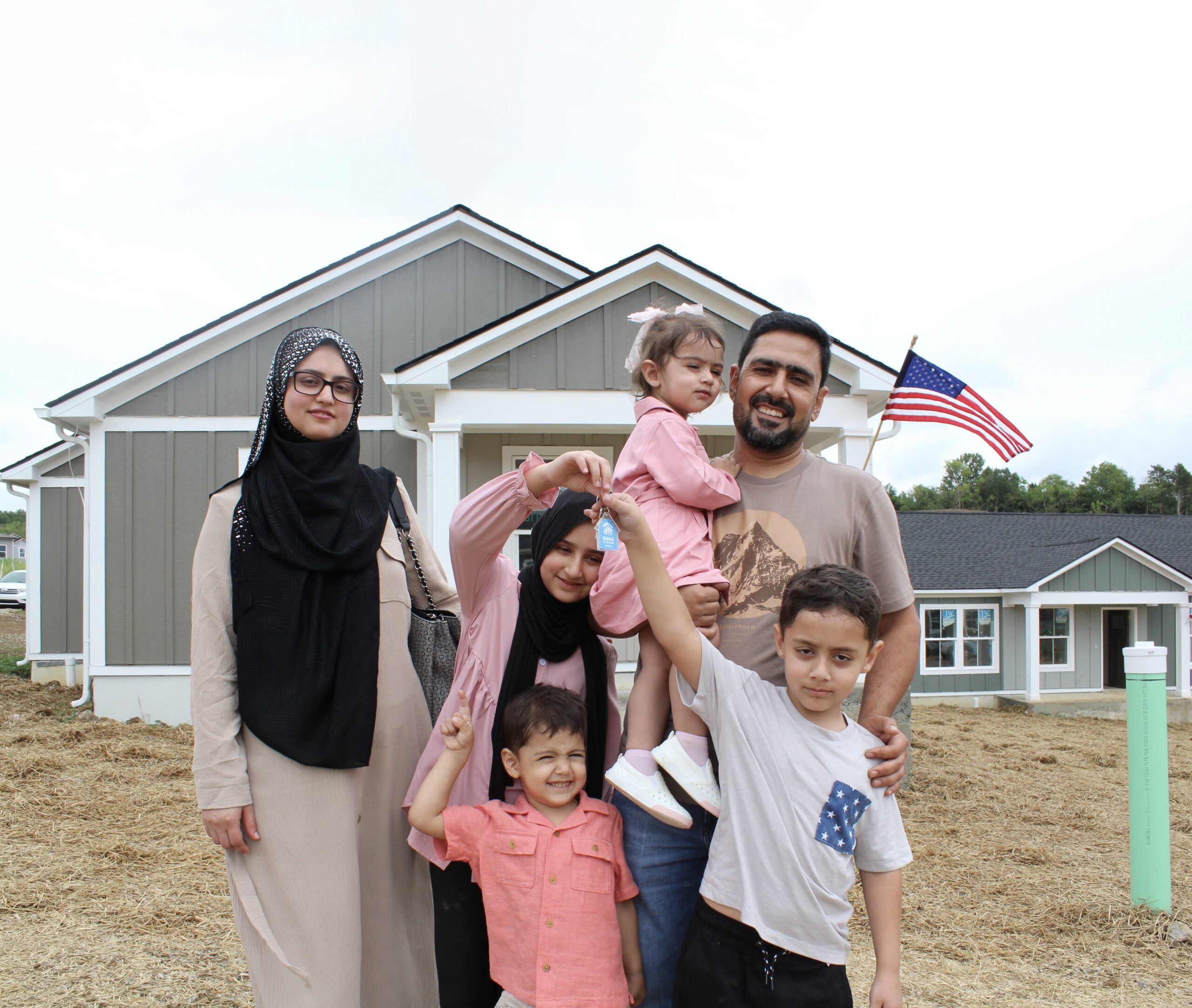 A family standing with the keys to their new home