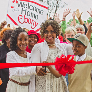 Ebony cutting the ribbon for her home